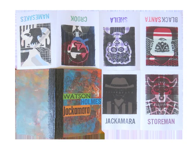The Jackamara book opened out: six small linocuts on cloth, each stamped with a title, Namesakes, Crook, Sheila, Black Santa, Jackamara and Storeman, beside the closed book.